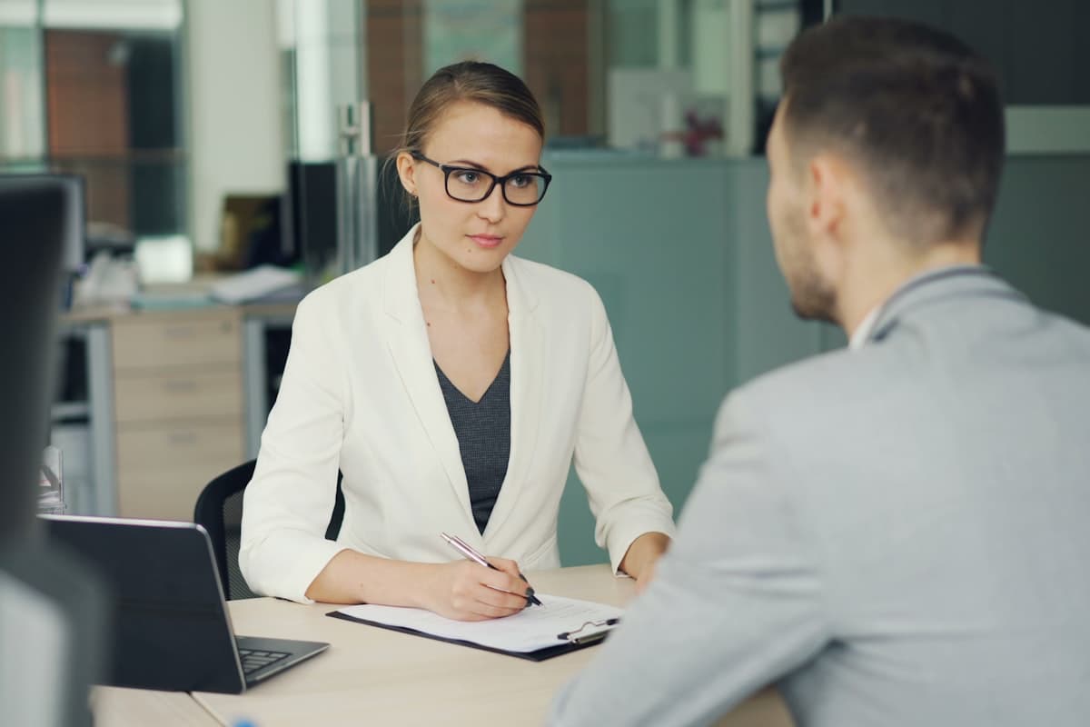 Entrevista de emprego entre recrutadora e candidato em escritório