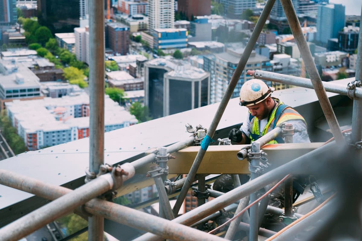 Profissional de segurança do trabalho inspecionando estrutura metálica em obra
